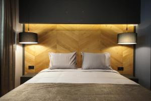 斯科普里伦敦住宿加早餐旅馆的一间卧室配有一张大床,上面有两盏灯