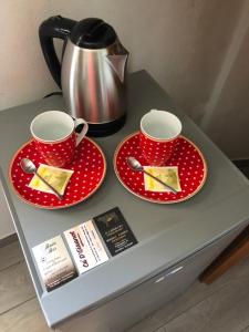 MiroglioAffittacamere Ca' d' Giuanot的一张桌子,上面有两个红盘和茶壶
