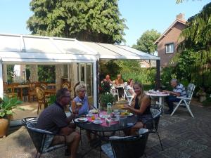 罗赫尔小葡萄园住宿加早餐酒店的一群人坐在庭院的桌子上