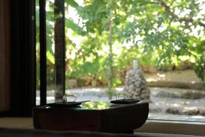 竹富岛竹富岛阿卡纳亚酒店的窗前带两杯的桌子