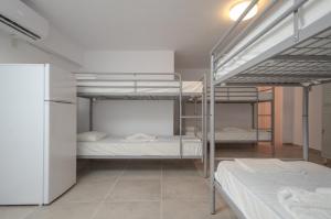 圣安娜纳克索斯Naxos Hostel的客房设有三张双层床和一台冰箱。