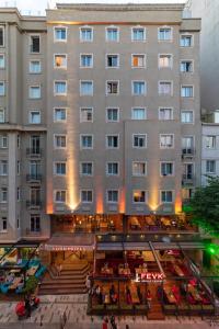 伊斯坦布尔Four Sides Taksim Lion Hotel&Spa的一座大型建筑,前面设有庭院