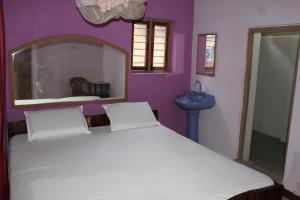 亨比Riverside Homestay的卧室配有白色的床和蓝色水槽