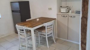 梅特拉赫Ferienhaus Schwalbennest的厨房配有木桌、椅子和冰箱。