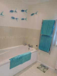 米德赫斯特Hysett House的浴室配有浴缸和墙上的蓝色鱼