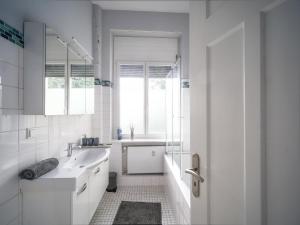 锡格堡锡格堡城市公寓的白色的浴室设有水槽和窗户。