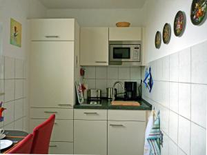 威斯巴登Ferienwohnung-Wiesbaden-Top3的小厨房配有白色橱柜和微波炉