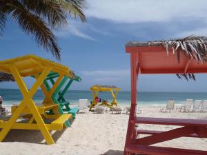 自由港市The Marlin at Taino Beach Resort的海滩上设有椅子和遮阳伞,还有大海