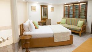 自由港市The Marlin at Taino Beach Resort的一间卧室配有一张床、一张沙发和一个浴缸