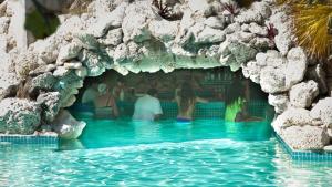 自由港市The Marlin at Taino Beach Resort的一群人坐在一个游泳池里的岩石洞里