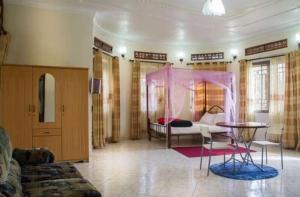 姆巴拉拉Palace Hotel的客厅配有床和桌子
