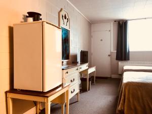Manitou曼尼通汽车旅馆的客房设有书桌和冰箱。