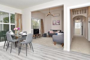 基督城Albemarle Villa - Christchurch Holiday Homes的用餐室以及带桌椅的起居室。