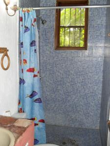 Pedro Gonzalez阿卡迪亚山林小屋的浴室设有淋浴帘,上面有鱼