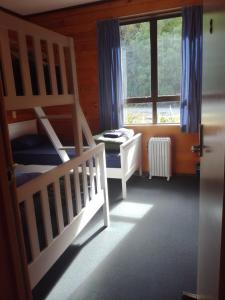 怀托摩洞穴JunoHall Backpackers的一间卧室设有两张双层床和一扇窗户。