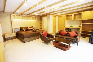 华欣华欣白沙酒店的一间卧室配有一张床、一张沙发和一张桌子