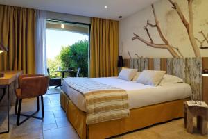 普罗普里亚诺巴塔西亚酒店的一间卧室配有一张床、一张书桌和一个窗户。