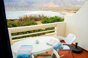 法马拉Seaview Risco de Famara 2的海滩景阳台配有桌椅