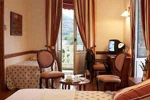 皮埃尔菲特－内斯塔拉法国大酒店的酒店客房带一张床、一张桌子和椅子