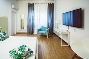 卡利亚里Bluemoon Sardinia的配有床、电视和椅子的房间