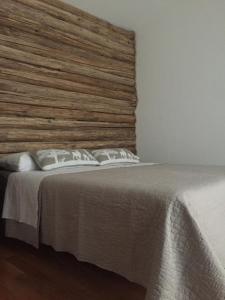 加约拉La Masca的一间卧室配有一张大床和木制床头板