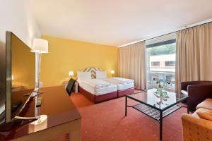 萨尔茨堡纽托快捷酒店的酒店客房配有一张床铺和一张桌子。