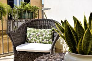 莱切Biccari6 Terrace Apartment的柳条椅,带枕头和植物