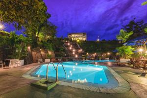 康提黄宝石酒店的一座游泳池,位于一座建筑的后面