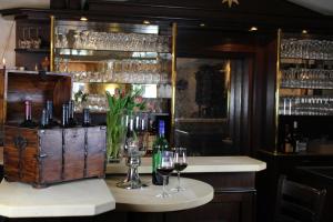 巴特诺因阿尔-阿尔韦勒Hotel Zum Stern的酒吧提供酒杯和葡萄酒瓶