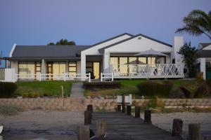 韦尔德里夫Rivertides Self Catering Guest House的海滩上带木板路的房子