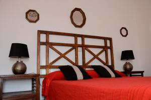 锡古恩萨Casa Rural ALCARREÑA的一间卧室配有一张红色的床和两盏灯