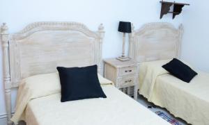锡古恩萨Casa Rural ALCARREÑA的一间卧室配有两张床、一盏灯和床头柜