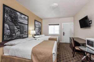 WatrousSuper 8 by Wyndham Watrous的酒店客房设有两张床和一台平面电视。