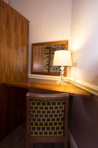 约克格鲁吉亚别墅和马厩酒店的一张桌子,里面配有一盏灯和一把椅子
