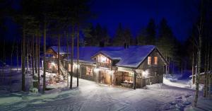 KiviperäIsokenkäisten Klubi - Wilderness Lodge的雪中的一个小木屋