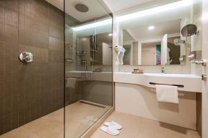 那不勒斯那不勒斯假日酒店的一间带玻璃淋浴和水槽的浴室