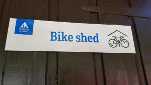 巴拉胡利什Glencoe Youth Hostel的挂在木栅栏上的自行车棚标志