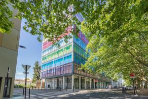 波尔多Appart'City Classic Bordeaux Centre的城市街道上一座高大的建筑,窗户色彩缤纷