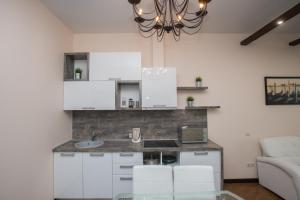 秋明Apart Hotel Abajour的厨房配有白色橱柜和玻璃桌