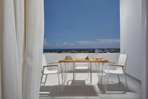 佩里沃罗佩特里套房酒店的海景阳台上的桌椅