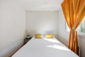 第戎Appart'City Classic Dijon - Toison D'Or的一间卧室配有一张带橙色窗帘的床
