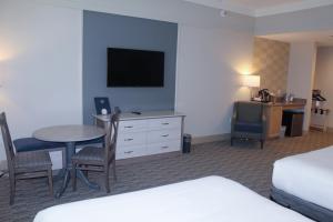 萨拉索塔Carlisle Inn Sarasota的酒店客房设有床、桌子和电视。