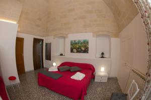 拉泰尔扎Il Rifugio di Laerte的卧室配有红色的床和墙上的绘画
