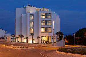 波尔Lifestyle Hotel Vitar - Adults Only的一座白色的建筑,前面有棕榈树