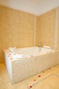 穆林加尔安妮布鲁克之家酒店的浴室配有浴缸,铺有红色鲜花。