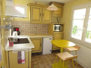 阿姆博斯Gîte La Pierre Qui Tourne的厨房配有黄色橱柜、桌子和水槽
