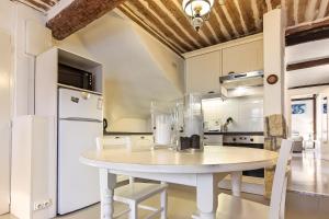 昂蒂布Bijou Apartment in Safranier - Old Town Antibes的厨房配有白色桌子和白色冰箱。