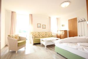 波金格Hotel Villa Sisi的一间卧室配有一张床、一张沙发和一把椅子