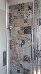 塞拉瓦莱·斯克里维亚B&b la valletta的一间带淋浴的浴室和瓷砖墙