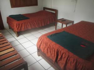 卡诺阿斯德蓬萨尔Mamaqocha的客房设有两张床,铺有瓷砖地板。